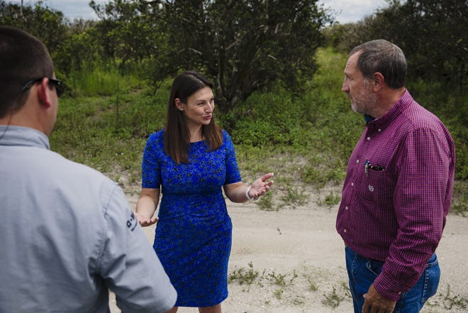 Florida Agriculture Commissioner Nikki Fried talks with Cody Lastinger, left, and Jeff Kreiger during one of her tours of orange groves. Fried wants to replace the trees with hemp plants. MUST CREDIT: Photo for The Washington Post by Scott McIntyre
