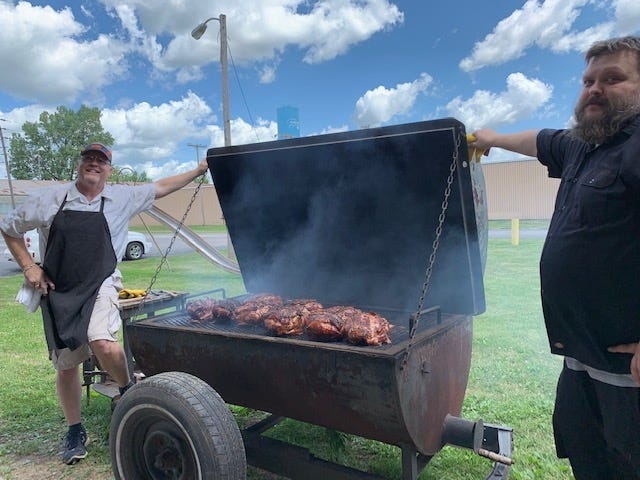 Eagles Lodge #2708 members Shawn Kelly, left, and Jeff Wyles, right, tend to the smoked meat while preparing for this weekend’s barbecue. Kelly said they will cook between 500-600 pounds of beef and pork in order to feed the community. [Photo by Jean Ann Miller/The Courier]
