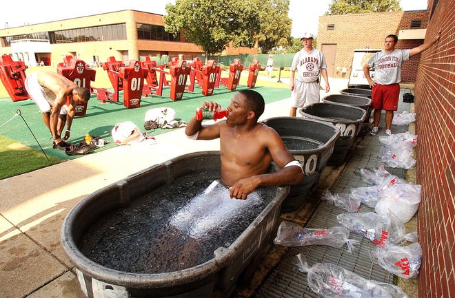 In this file photo, a University of Alabama cornerback enjoys a cold beverage while sitting in a tub of icewater after a hot practice. All high schools in Sarasota and Manatee counties are now equipped with cold water submergence tubs or troughs. [FILE PHOTO / TUSCALOOSA NEWS]