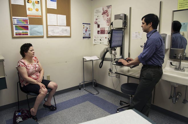 A patient speaks with a primary care doctor in Oregon, which is among the states that expanded Medicaid under the Affordable Care Act. [AP Photo/Gosia Wozniacka/ File]