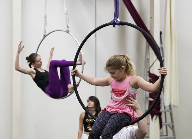 Willa Holland, 7, front, and Bridget DeLonjay sit in lyras at Aerial Dance PC on July 5. Aerial Dance PC is offering a Superhero Aerial Dance Camp on July 15-16 for ages 4-7. [JOSHUA BOUCHER/THE NEWS HERALD]