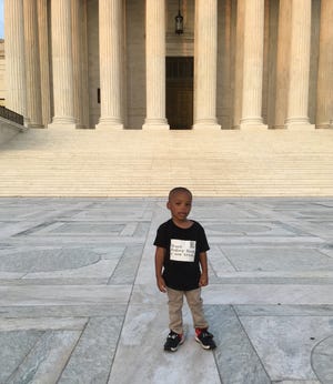Rodrick Reed Jr., 2, the nephew of death row inmate Rodney Reed, stands before the U.S. Supreme Court building protesting his uncle's conviction with his family. [Photo courtesy of Reed Justice Initiative]