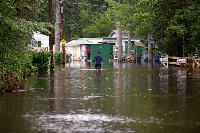 A resident walks through flood water on Crystal Avenue in Southampton, June 20. [DAVE HERNANDEZ / FILE]
