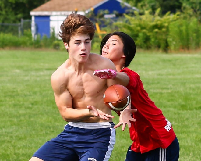 Winnacunnet's Tucker McCann makes a catch as Min Batchelder defends during Wednesday morning's workout in preparation for Saturday's 7v7 passing tournament at Exeter High School. [Matt Parker photo/Seacoastonline]
