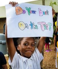 Emma E. Booker Elementary School first-grader Taraji Lamb holds a sign of encouragement for her classmates earlier this year. [HERALD-TRIBUNE STAFF PHOTO / DAN WAGNER]
