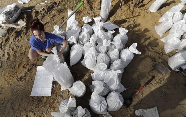 Ashley Boudreaux ties sandbags in Baton Rouge, La., on Friday ahead of Tropical Storm Barry. [AP PHOTO]