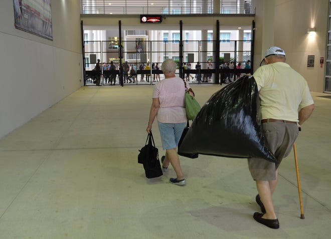 Fran and John Marshall of Osprey carry some of their evacuation supplies from their car as they head into the disaster shelter at Riverview High in Sarasota in advance of Hurricane Irma on Sept. 10, 2017. A new survey wants to better understand hurricane experiences and perceptions of seniors in Sarasota County and the City of Venice. [HERALD-TRIBUNE ARCHIVE / 2017 / MIKE LANG]