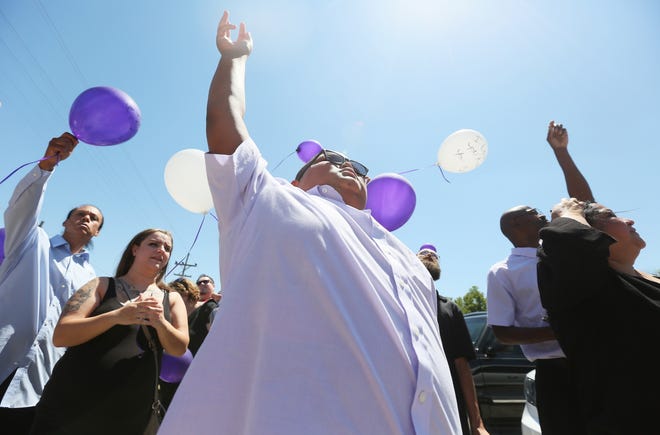 Zavien LeShore, 11, center, lets off a balloon during a celebration of life for his sister, Chelsey Chaffin, on Saturday at the New Resurrection Church alongside his mother, Michelle. Chelsey was killed in May. [Michael Stavola/HutchNews]