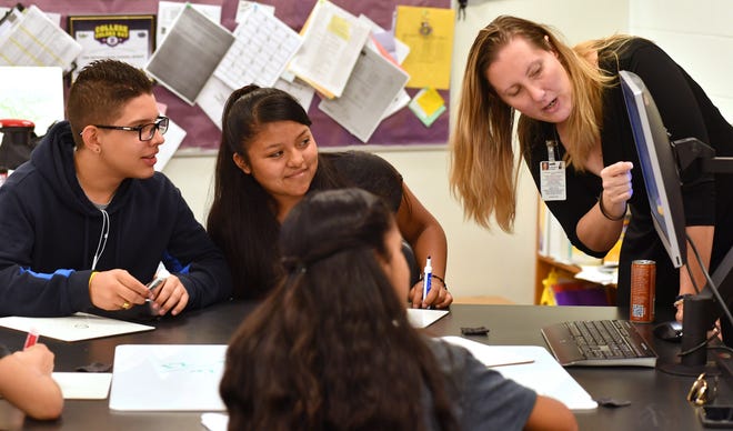 Booker Middle School eighth-graders Juan Esteban Areiza, left, and Monserrat Soreque, center, work with pre-algebra teacher Lindsay Rowe during a review for the Florida Standards Assessment in May. The FSA scores determine school grades, which were released this week with Booker Middle earning a B. [Herald-Tribune Archive / Mike Lang]