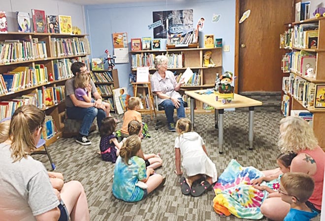 Jean Jones guest reads at the Haviland Public Library earlier this summer. A free storytime for children ages 3-6 is offered from 2-2:30 p.m. every Wednesday through the summer until August 7. Guest readers are coffee shop locals or Haviland residents who support the summer reading program. [Liz Ballard/Pratt Tribune]