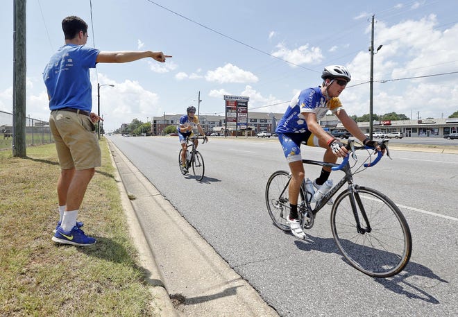 Public relations coordinator Pat Lynch signals to Grant Uselman, left, a junior at the University of Washington, and Joel Hurzler, a junior at the University of Colorado Boulder, as he marks an upcoming turn from 15th Street onto Hackberry Lane during the annual Journey of Hope through Tuscaloosa Monday, July 20, 2015. The ride is to raise awareness and support for people with disabilities. Members of the Pi Kappa Phi fraternity from all over the United States are participating in the journey which began in Long Beach, Ca. on June 12 and concludes in Washington D. C. on Aug. 8. The bikers were traveling 101 miles Monday and typically average about 75 miles a day. Staff Photo | Michelle Lepianka Carter