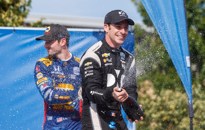 Simon Pagenaud, right, of France, celebrates in the Winner's Circle after taking first place at the Honda Indy auto race in Toronto, Sunday, July 14, 2019. (Mark Blinch/The Canadian Press via AP)