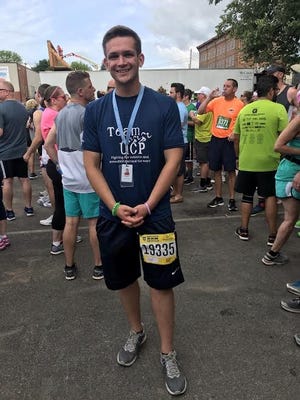 New Hartford's Ben Phelps, a behavior specialist assistant at Upstate Cerebral Palsy’s Chadwicks campus, was all smiles at the Boilermaker Post-Race Party after running alongside UCP staff and students in the 5K. [MARQUEL SLAUGHTER / OBSERVER-DISPATCH]