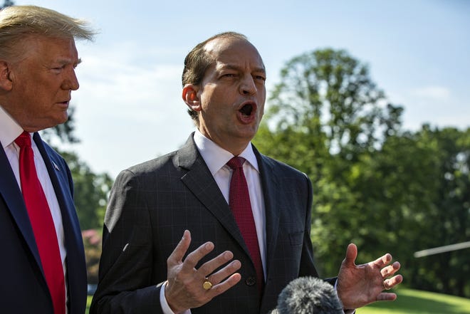 Labor Secretary Alex Acosta speaks to reporters as President Donald Trump looks on outside the White House Friday. Acosta said he will resign following controversy over his handling of a sex crimes case involving the financier, Jeffrey Epstein, when he was a prosecutor in Florida. [Samuel Corum/The New York Times]