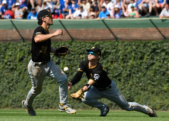 Pittsburgh Pirates right fielder Bryan Reynolds, right, makes a catch as second baseman Adam Frazier moves pout of the way during the seventh inning Sunday, July, 14, 2019, in Chicago. [DAVID BANKS/THE ASSOCIATED PRESS]