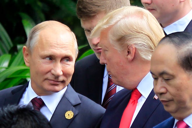 Russian President Vladimir Putin and President Donald Trump talk as they arrive for a photo session during the Asia-Pacific Economic Cooperation Summit in Vietnam in 2017. [AP Photo/Hau Dinh]