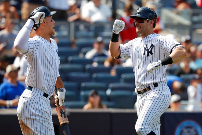 New York Yankees' on-deck batter Aaron Judge, left, celebrates with New York Yankees left fielder Mike Tauchman after Tachman hit solo home run during the seventh inning of a baseball game against the Toronto Blue Jays, Sunday, July 14, 2019, in New York. (AP Photo/Kathy Willens)