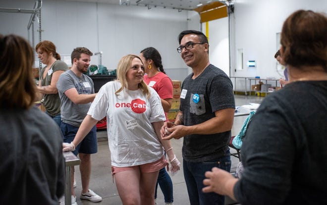 Jennifer Forchelli, 38, and Tim Elias, 51, joke around while volunteering at Central Texas Food Bank in Austin on July 3. After meeting on Swoovy, a new Austin-based dating app that connects matches to volunteer opportunities, the two pulled damaged leaves off cabbages for their first date. [Angela Piazza for Statesman]