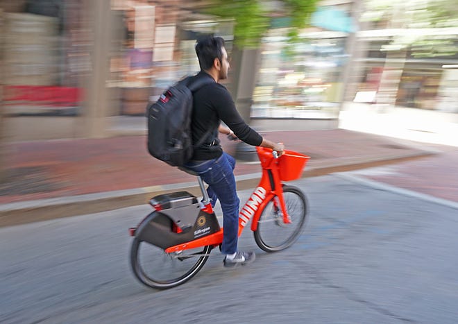 A rider zips down Providence's Westminster Street on a JUMP bike. [The Providence Journal / Sandor Bodo]