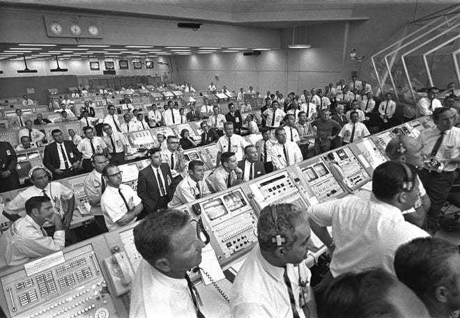 This July 1969 photo provided by NASA shows launch controllers in the firing room at the Kennedy Space Center in Florida during the Apollo 11 mission to the moon. In the third row from foreground at center is JoAnn Morgan, the first female launch controller. "I was there. I wasn't going anywhere. I had a real passion for it," Morgan said in a July 2019 interview. "Finally, 99 percent of them accepted that 'JoAnn's here and we're stuck with her.' " (NASA via AP)