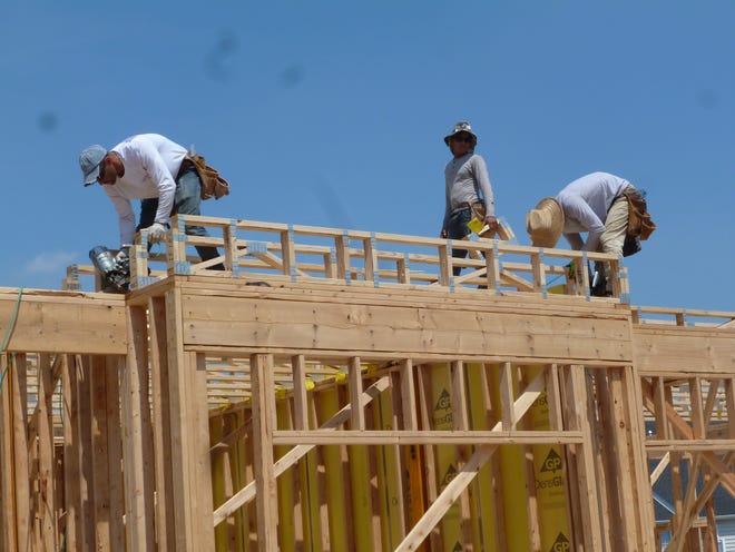 Workers for McGrath Homes make sure they wear hats to protect from the sun as they frame out a house at the St. Joseph Court development in Falls on Tuesday.

[PEG QUANN / STAFF]