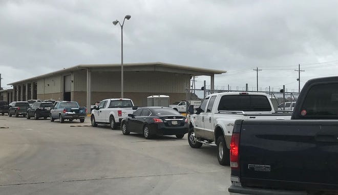 A line 30-cars deep stretched to Bayou Road on Friday afternoon as residents waited at the Iberville Parish Maintenance Facility to stock up on sandbags.