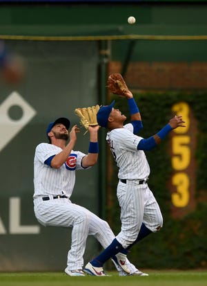 Chicago Cubs second baseman Addison Russell, right, catches a fly ball hit by Cincinnati Reds' Yasiel Puig while colliding with teammate Kris Bryant during the first inning Monday, July 15, 2019, in Chicago. [PAUL BEATY/THE ASSOCIATED PRESS]