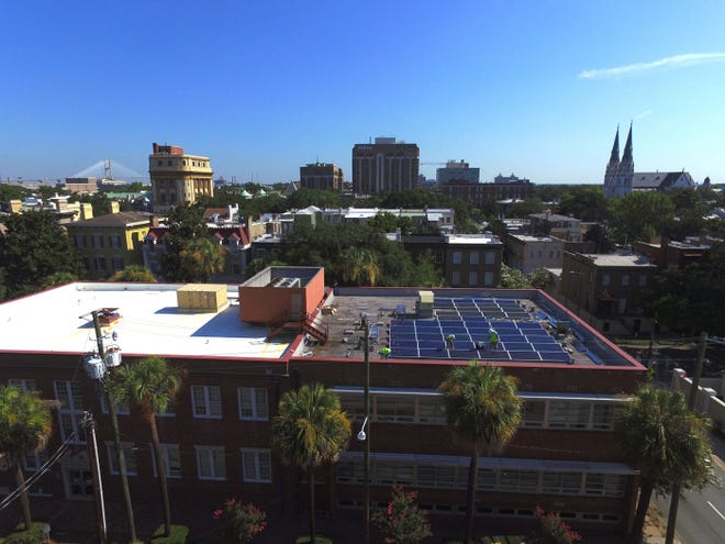 Workers from Hannah Solar install donated solar panels on the United Way building on Monterey Square in 2016. In a decision Tuesday, Georgia regulators added a record amount of solar to the grid, most utility-scale but some rooftop as well. [Photo courtesy Hannah Solar]
