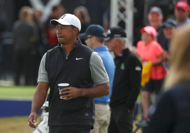 Tiger Woods of the United States holds a drink as he walks through the practice range ahead of the start of the British Open golf championships at Royal Portrush in Northern Ireland, Tuesday, July 16, 2019. The British Open starts Thursday. (AP Photo/Jon Super)