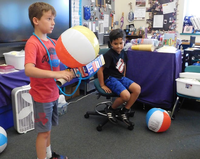 The Mohawk Valley Center for the Arts is sponsoring a STEAM camp for students this week at Benton Hall Academy n Little Falls. Luke Lamanna is pictured showing his beach ball boogie board while students worked on their projects. Marek Camerdello is seated looking on. [STEPHANIE SORRELL-WHITE/TIMES TELEGRAM]