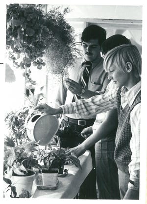 Charlie Howard, right, waters plants in the Portsmouth High School greenhouse. In the middle of the photo is Robert Lister, who was Howard’s teacher during his high school years. Howard, who was gay, was murdered when he was 23 in Bangor, Maine. [Courtesy photo]