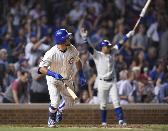 Chicago Cubs' Kyle Schwarber watches his game-ending solo home run while teammate Javier Baez back, celebrates during the 10th inning of a baseball game against the Cincinnati Reds on Tuesday, July 16, 2019, in Chicago. (AP Photo/Paul Beaty)
