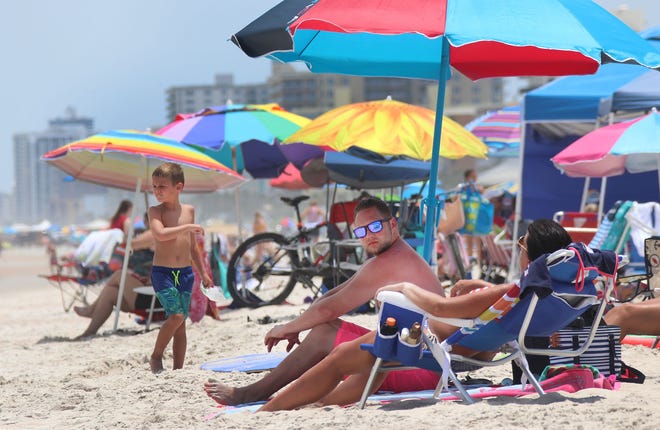 Colorful umbrellas help beachgoers beat the heat on Thursday, July 18, 2019 near SunSplash Park in Daytona Beach. Skies are expected to be sunny over the weekend, and surf will remain flat. [News-Journal/David Tucker]
