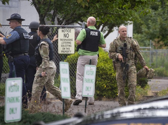 Oregon State Police SWAT Team members secure the scene of a shooting at a Foster Farm plant in Corvallis. [Chris Pietsch/The Register-Guard]