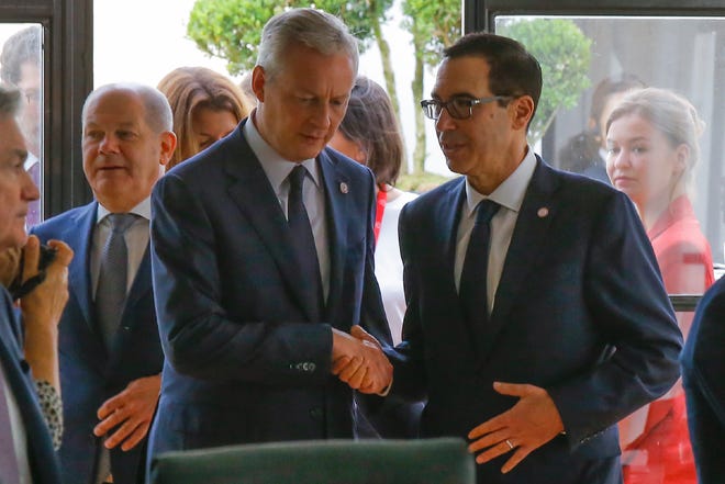 U.S. Treasury Secretary Steve Mnuchin, right, and German Finance Minister Olaf Scholz shake hands at the G-7 Finance meeting Thursday in Chantilly, France. [AP photo / Michel Euler]