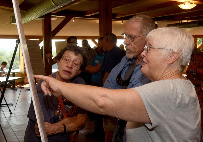 Rocheport residents, from left, Margaret and John Preus and Blenda Marquardt look at one of the information boards set up Thursday by MoDOT at Les Bourgeois Winery that gives details about the I-70 Rocheport Missouri River Bridge rehabilitation project. [Don Shrubshell/Tribune]