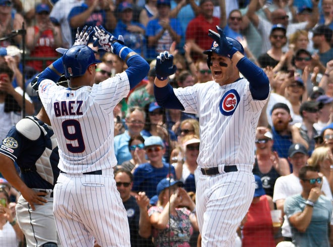 Chicago Cubs' Anthony Rizzo, right, is greeted by Javier Baez (9) after hitting a grand slam home run against the San Diego Padres during the third inning of a baseball game, Friday, July,19, 2019, in Chicago. (AP Photo/David Banks)
