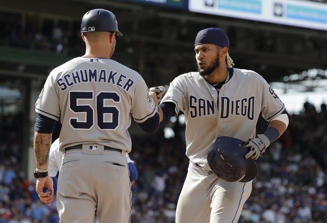 San Diego Padres' Fernando Tatis Jr., right, celebrates with first base coach Skip Schumaker after hitting a two-run single during the ninth inning of a baseball game against the Chicago Cubs on Sunday. [NAM Y. HUH/THE ASSOCIATED PRESS]