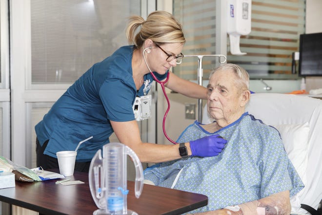 In this July 16, 2019, photo provided by the VA Eastern Colorado Health Care System, nurse Renee Whitley checks on George Barrett, 85, as he recuperates from open-heart surgery at the Rocky Mountain Regional VA Medical Center in Aurora, Colo. The hospital helped the American College of Surgeons test new standards to improve surgical care for older adults. (Shawn Fury/VA Eastern Colorado Health Care System via AP)