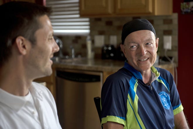 In a Tuesday, July 9, 2019 photo, Bob Falkenberg visits his bone marrow donor Jason Rottman in Caledonia, Mich. during his 4,000 mile bicycle journey. Bob is in remission of leukemia and is riding his bike with another survivor to raise awareness for the bone marrow registry "Be the Match." (Alyssa Keown/The Grand Rapids Press via AP)