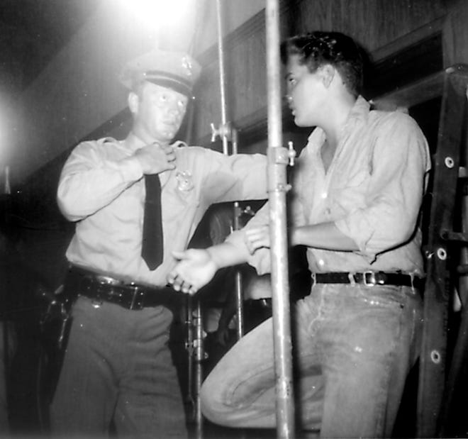 Elvis films a commercial in Ocala on July 22, 1961. Elvis stands with Red West, part of the Memphis Mafia, while shooting at the Commerical Bank and Trust Co. of Ocala. Part of the movie, "Follow That Dream," was filmed in Ocala. [Louise Sherouse/File]