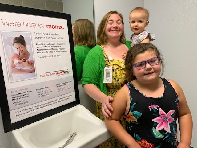 Sara Notto, a breastfeeding peer counselor at the Logan County Department of Public Health, inspected the new restroom with an area designated for mothers who are breastfeeding. With Notto are her children Lily Notto standing in front and Isla Rose Notto being held by her mother. [Photo by Jean Ann Miller/The Courier]