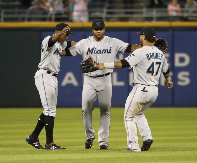 The Miami Marlins from left, Curtis Granderson, Cesar Puello, and Harold Ramirez celebrated the team’s 5-1 win over Chicago on the White Sox’s field Tuesday. [Charles Rex Arbogast/The Associated Press]