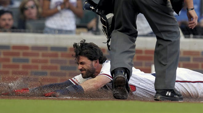 The Braves' Dansby Swanson slides safely into home plate on a hit against the Kansas City Royals during the first inning of a game Tuesday in Atlanta. [TAMI CHAPPELL/THE ASSOCIATED PRESS]