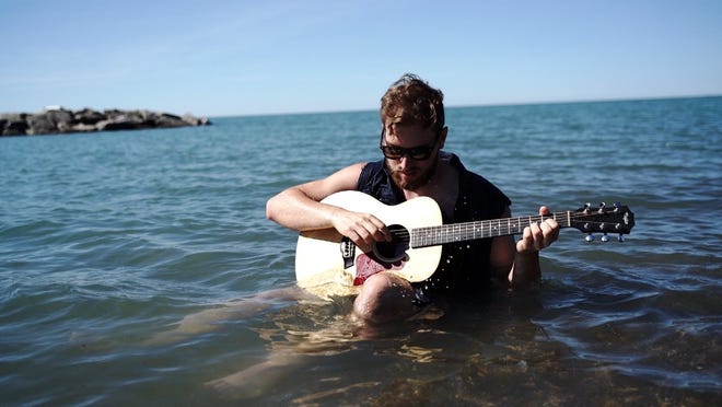 Jonah Krull plays "water guitar" in Lake Erie just off Presque Isle State Park in the video for his song "Erie." Krull was recently signed to play at Celebrate Erie on Aug. 18 at 1 p.m. on the Perry Square stage. [CONTRIBUTED PHOTO]