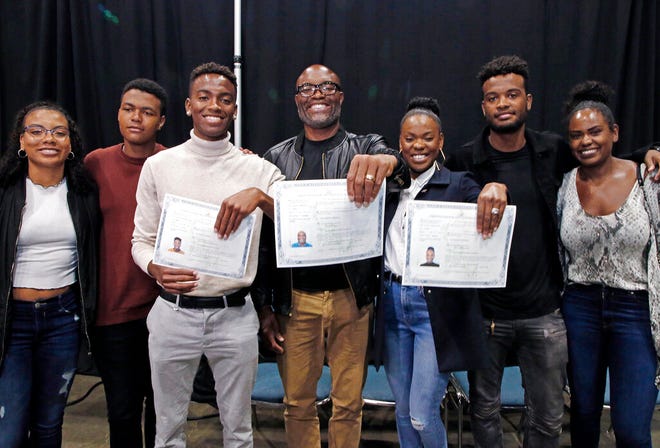Mixed martial arts great Anderson "Spider" Silva of Brazil, center, his daughter Kaory, 23, right, and son Kalyl, 20, left, hold their citizenship documents after they are sworn in as U.S. citizens in a mass naturalization ceremony, Tuesday, July 23, 2019, at the Los Angeles Convention Center. Joining them are family members who are not yet citizens, from left, daughter Kauana, 18; son Joao, 14; and son Gabriel, 22, and Anderson Silva's wife Dayane.