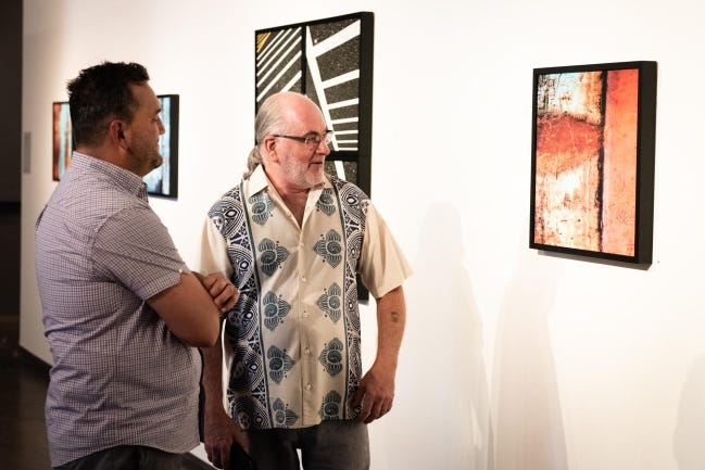 Lawrence Hultberg, right, discusses one of his photos on display at Urban Abstracts. [Evan Beasley Photo]