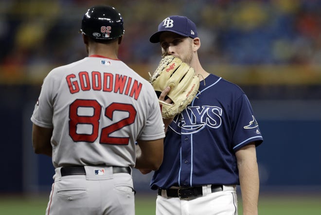 Tampa Bay pitcher Adam Kolarek talks to Boston first base coach Tom Goodwin after Kolarek was moved to first base during the eighth inning of Wednesday's game. It led to a protest by the Sox. [AP photo]