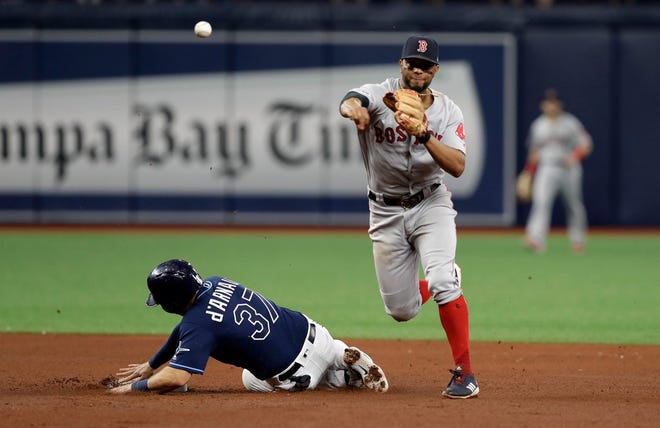 Red Sox shortstop Xander Bogaerts forces Tampa Bay's Travis d'Arnaud out at second base and relays the throw to first in time to turn a double play on Tommy Pham during Wednesday's game in St. Petersburg, Fla.