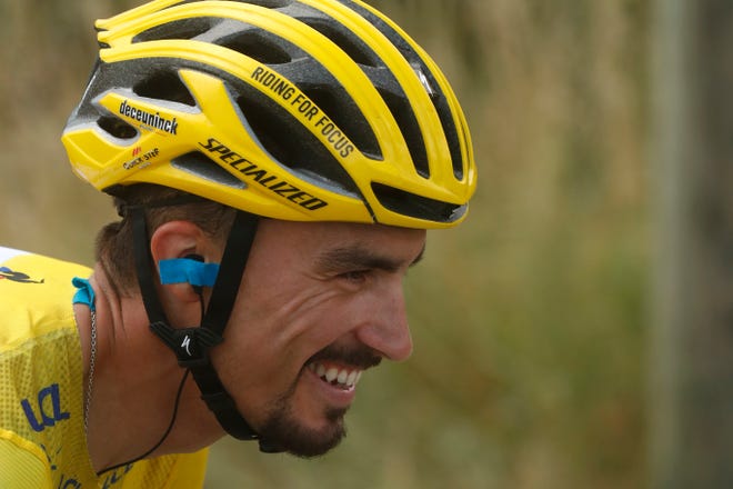 France's Julian Alaphilippe wearing the overall leader's yellow jersey smiles as he rides during the 17th stage of the Tour de France over 200 kilometers (124.27 miles) with start in Pont Du Gard and finish in Gap, France, on Wednesday. [Thibault Camus/The Associated Press]